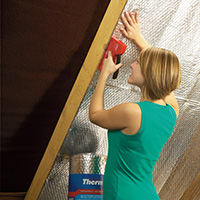 A woman fitting Airtec YBS insulation in her home