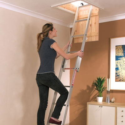 A woman climbing up a loft ladder.