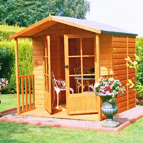 A wooden summer house with double doors in a garden.