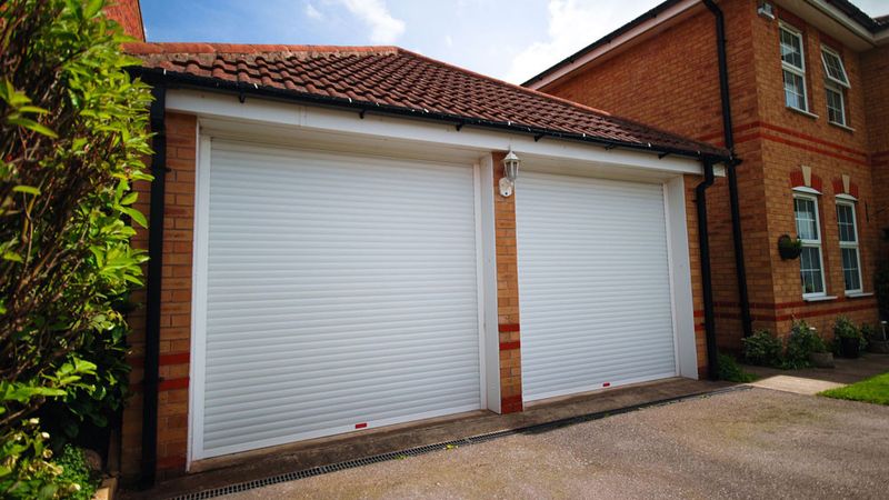 Spacious garage with two white garage doors